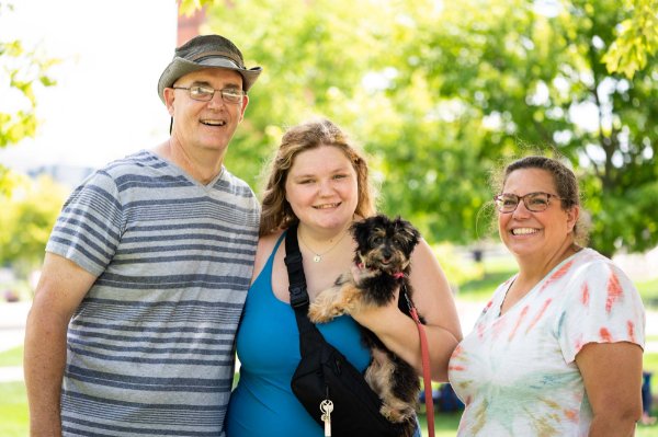 student and her supporters stand outside, three people standing