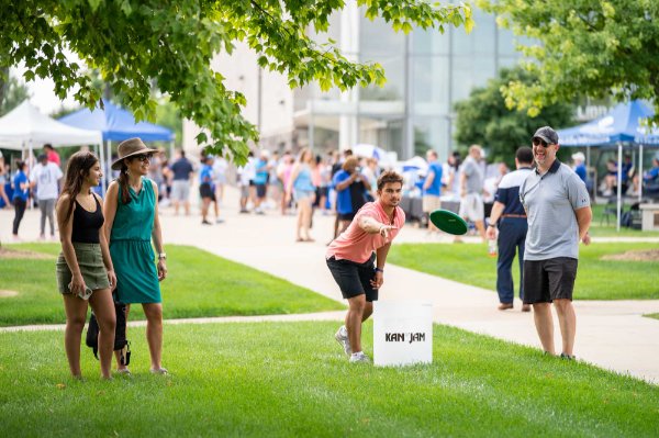 student throws a disc while others look on