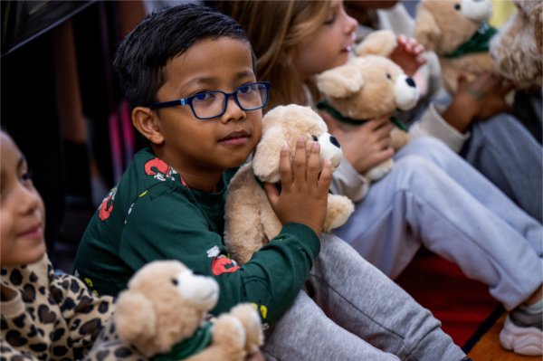 Kaius Mandigma, a second grade student at Vanderbilt Charter Academy, cuddles with a stuffed animal given out by Priority Health as part of the Priority Pups program. 