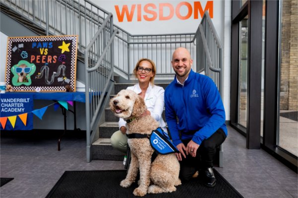 Abbey Sladick with Priority Health and Grand Valley alumna, left, and Michael Cousins, assistant vice president of communication and outreach for the Division of K-12 Education Innovation and Scholar Success, pose with Jasper.