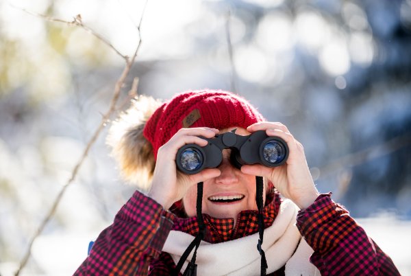 Jenny Jenkins smiles as she looks through binoculars.