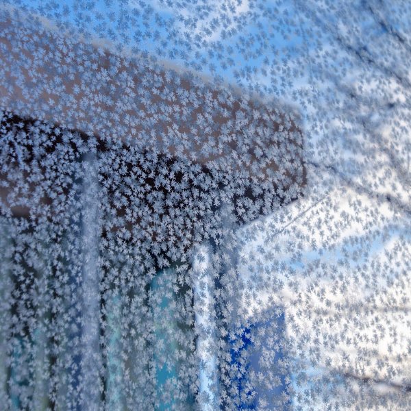 A campus building is seen through frost on glass