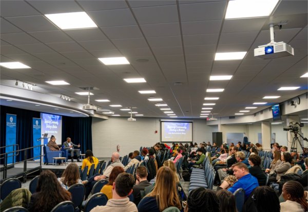 crowd seated in chairs in the Kirkhof Center, listening to presentation