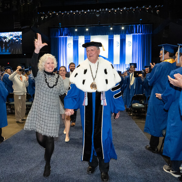 President Haas and Marcia Haas walking down aisle at commencement.