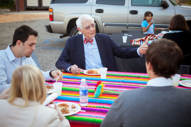 man with others at picnic table