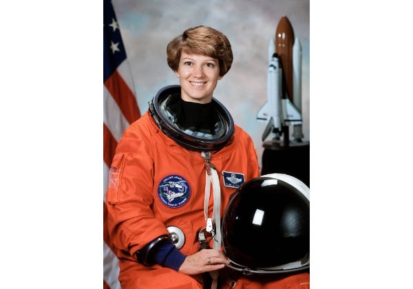 A portrait of Eileen Collins in her orange astronaut uniform