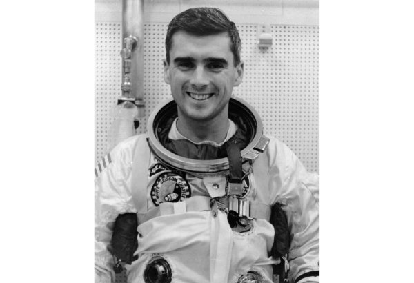 A black and white photo of Roger Chaffee in a white astronaut uniform