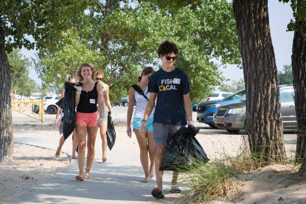 Students walk through park looking for trash