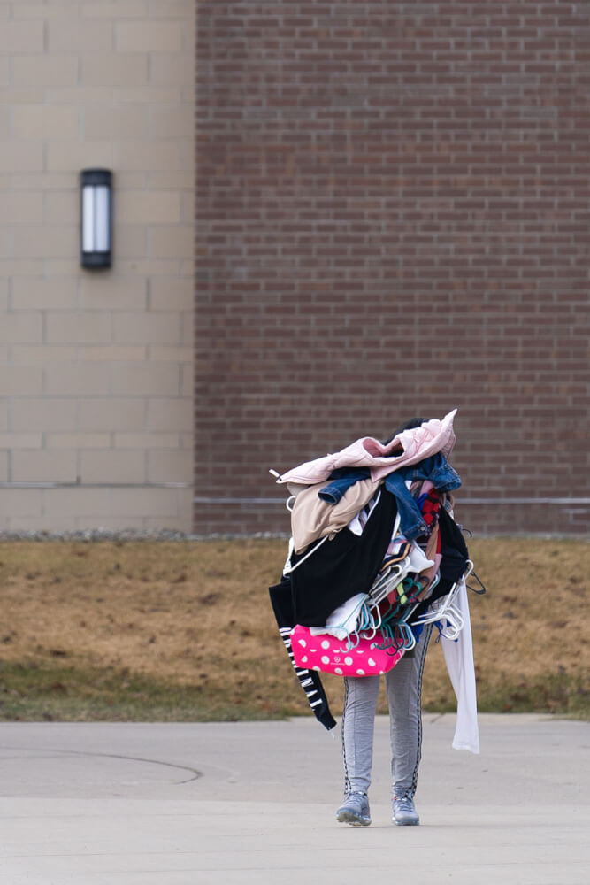 person holding so many clothes, can't see face