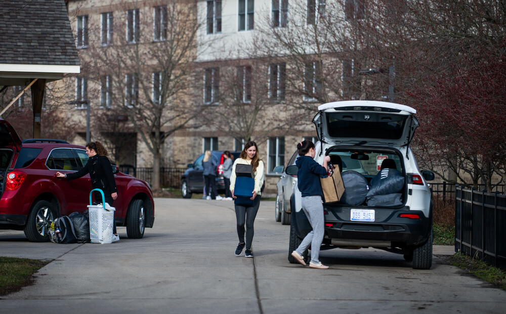 people filling car with belongings