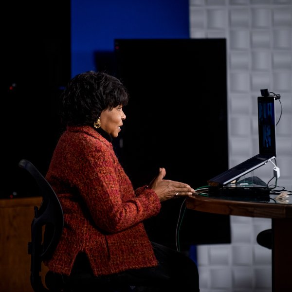 Cheryl Brown Henderson gives a virtual presentation standing behind a monitor in the WGVU studio.