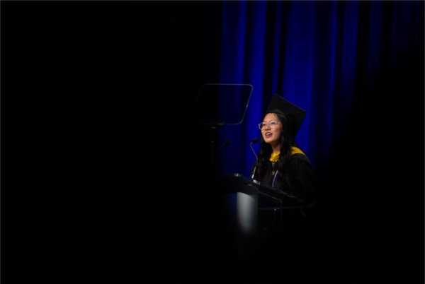  A student speaker gives a Commencement speech behind a lectern. 