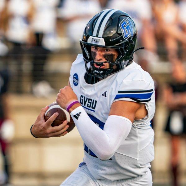 A Grand Valley football player runs with the football.