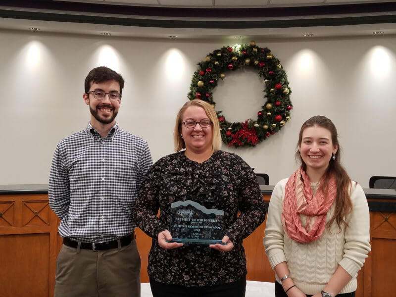 Lab manager Michael Hassett, research assistant Maggie Oudsema, and graduate student Emily Kindervater accept the watershed award from the Macatawa Area Coordinating Council.