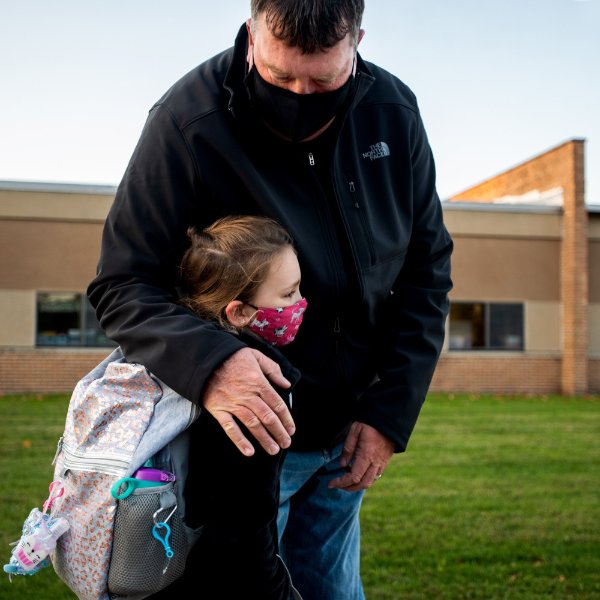 Avoca Alway hugs her dad, Rob Alway, as he walks her to Scottville Elementary School.