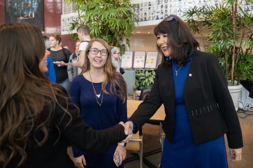 President Mantella shakes a student's hand