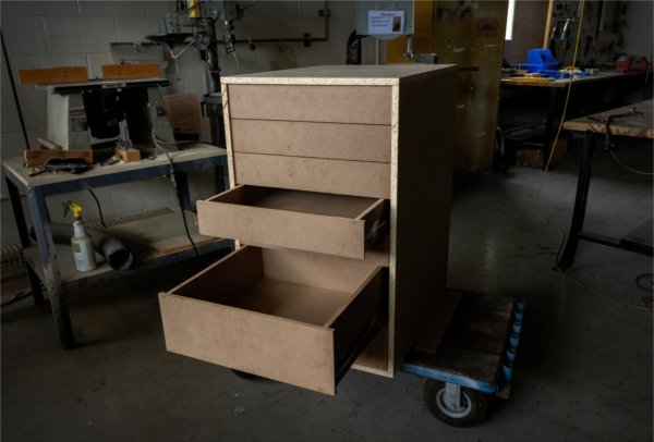 cabinet in a woodshop with some drawers open