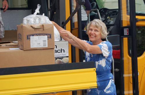 Linda Masselink, senior librarian, helps stuff the bus