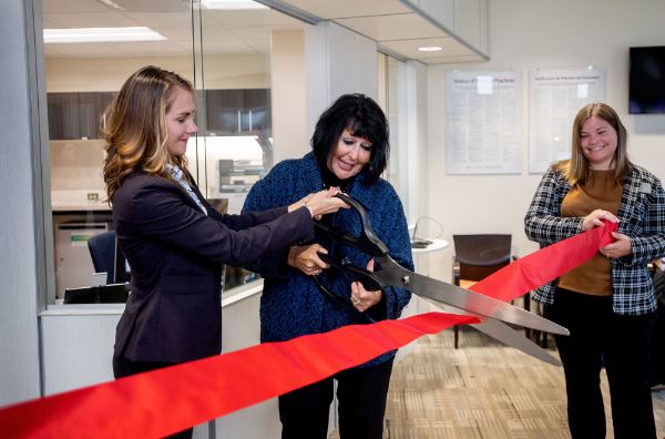 Cutting a celebratory ribbon are, from left, Dr. Kristen Woods, president of Trinity Health Medical Group; GVSU President Philomena V. Mantella; and Kate Harmon, GVSU acting assistant vice president for Student Affairs.