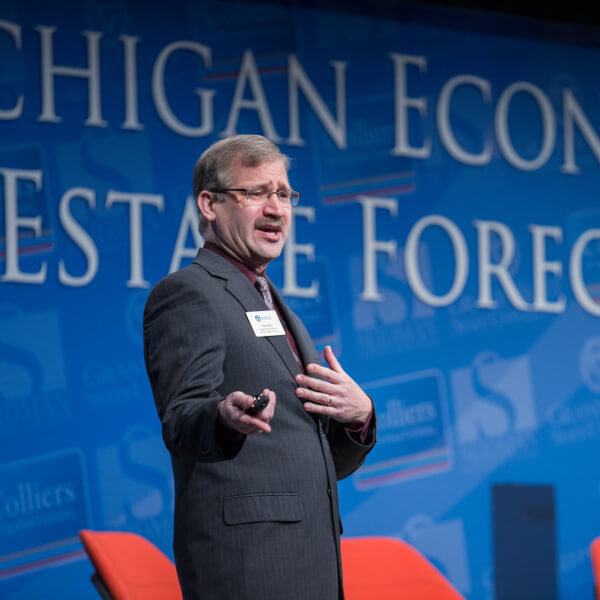 Paul Isely presents his economic forecast on stage.