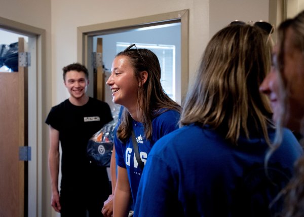 Connor Pung and Brianna Tipple laugh together as they stand in a dorm room.