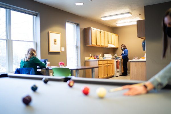 Students in Winter Hall gather in the common room, which includes a pool table and full kitchen. 