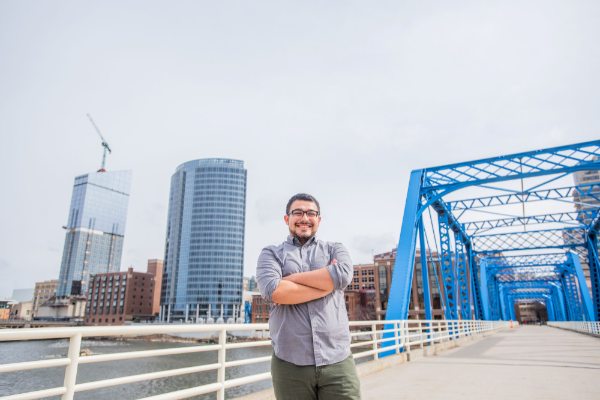 Gerardo Vasquez, who is a social work major, stands on the Blue Bridge in Grand Rapids. 