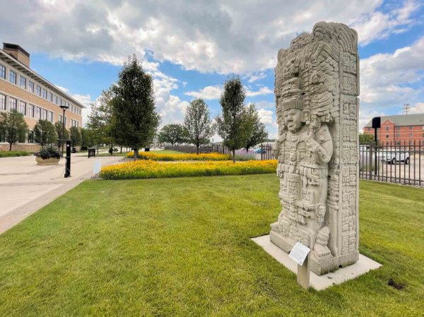 The sculpture "Mayan Stelae Of King K'ak' Tiliw Chan Topaat" is installed on grass outside the L. William Seidman Center.