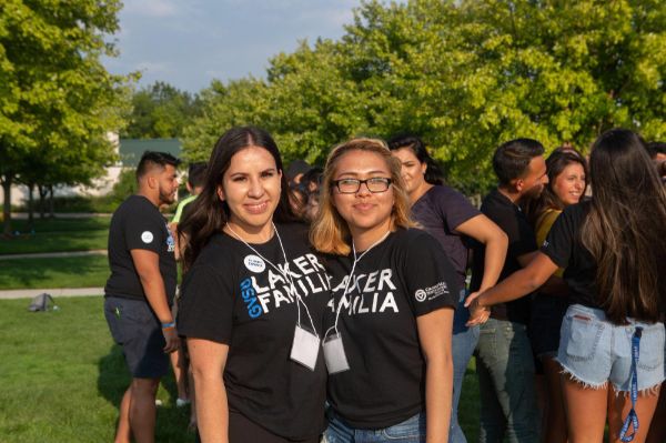 Two people pose together outdoors wearing matching black t-shirts that read 'Laker Familia'