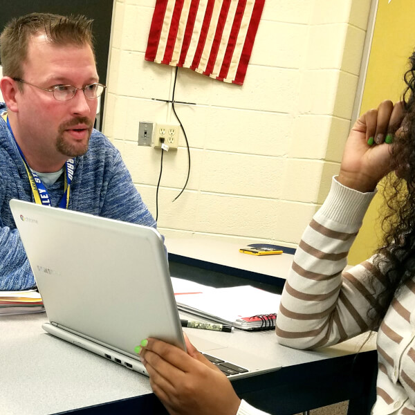 Jeremy Bissett works with a student from Godwin Heights High School.