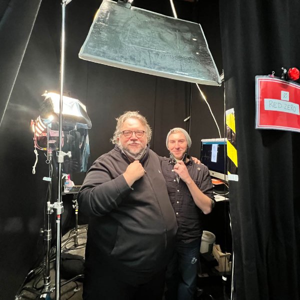 Guillermo del Toro, left, and Jesse Gregg posing backstage and pulling down their face masks