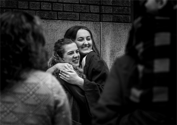 From left, Jacyln Brubaker hugs Avery Howe, who graduated with a bachelor of science in allied health sciences during Commencement at Van Andel Arena May 2.
