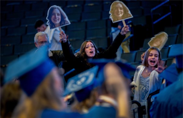 Family members try to get the attention of a graduate as they recess from Saturday afternoon&#8217;s Commencement ceremony at Van Andel Arena May 2.