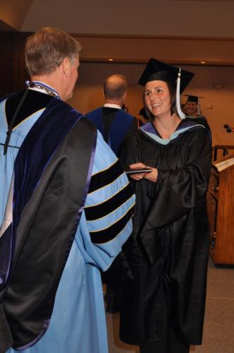 President Thomas J. Haas congratulates a graduating student during the Traverse City commencement ceremony in 2012.