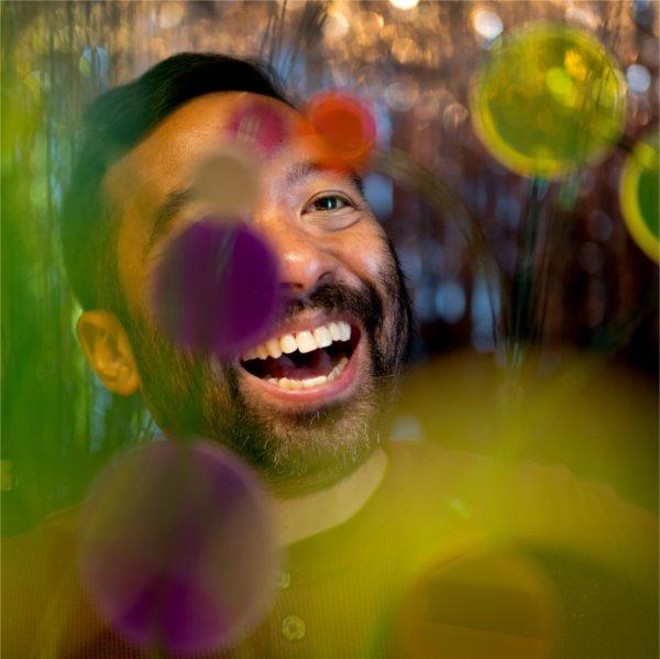 Jeffrey Augustine Songco will be the newest artist to serve as the Padnos Distinguished Artist-in-Residence. He is pictured with his acrylic flowers inside his Allendale home art studio.