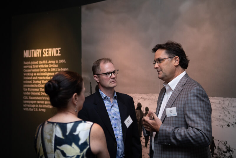 Brian Hauenstein, Ralph Hauenstein's grandson, discusses the exhibit with guests.