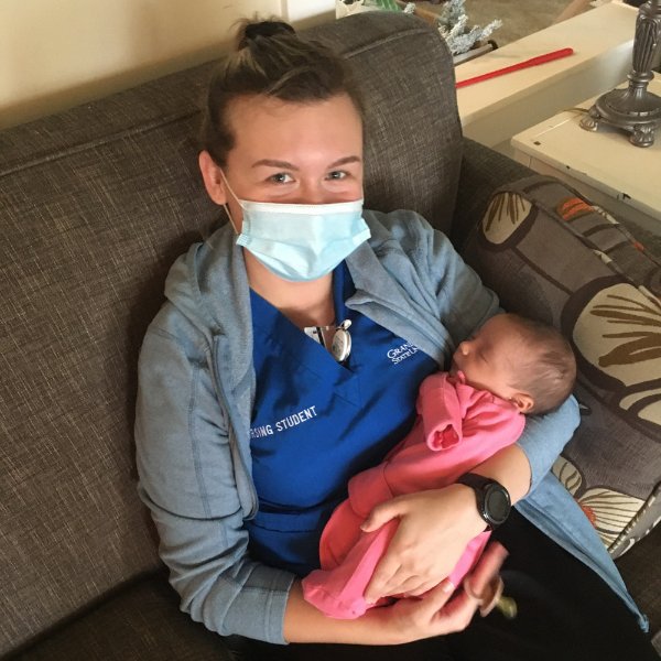 Kassandra Schuling holds a newborn baby during a community health rotation