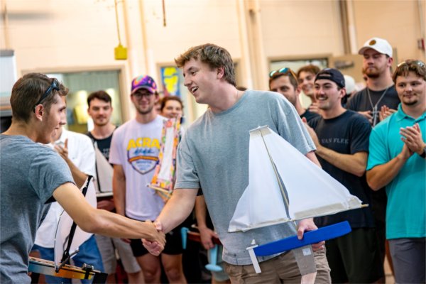 Isaac Haapala, left, and Grant Hayford, right, show good sportsmanship after Hayford won first place for speed at 3.66 seconds across the tank. Haapala, now a senior, was the race winner last year.