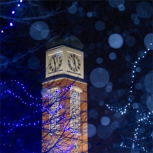 The clock tower is illuminated as snow falls across Valley Campus at night during a snow storm on Jan 19.