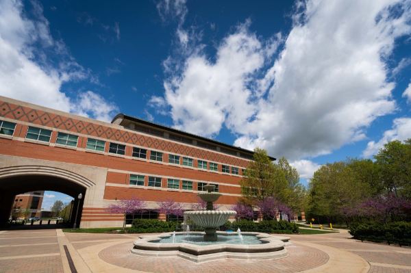 Padnos Hall photo with blue sky, clouds and fountain 