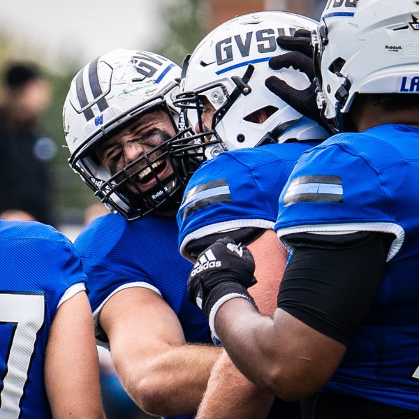 Lakers football players celebrate a play