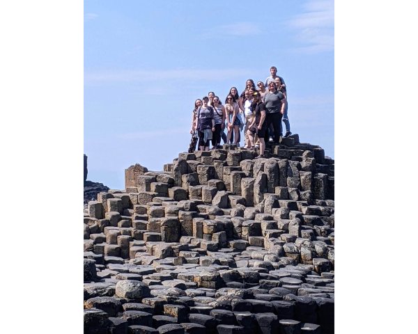 group of students standing on top of a rock formation
