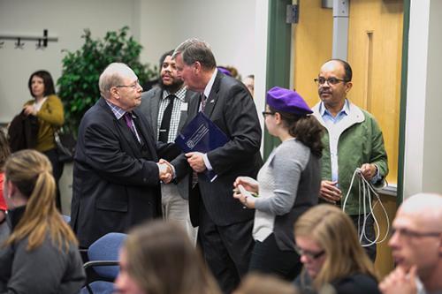 Photo by Steven Herppich    President Thomas J. Haas greets José Jiménez at an event March 29 that celebrated the expansion of the Young Lords oral history collection. The collection now includes oral histories from area senior citizens.