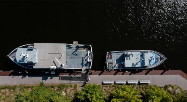 A drone photo of two boats docked in water.  