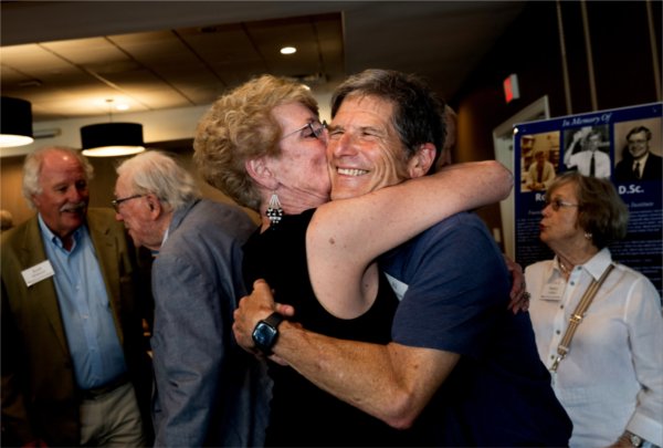 Two people embrace with smiles on their faces. 