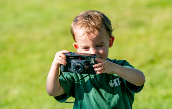 A young child uses a small camera to take photos. 