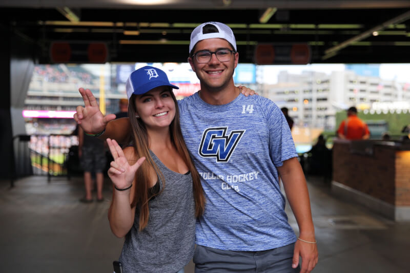  Two students hugging displaying the Laker Up hand sign