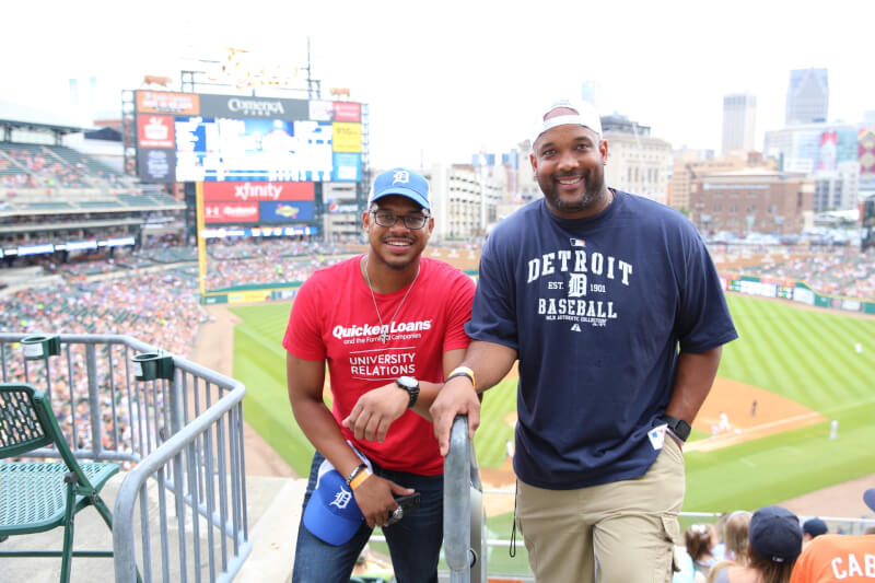  Two students standing with the Comerica Park behind them