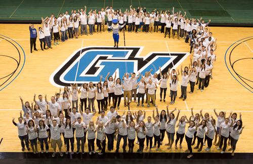Laker twins, with President Thomas J. Haas and Louie the Laker, form a 2 in the Fieldhouse.