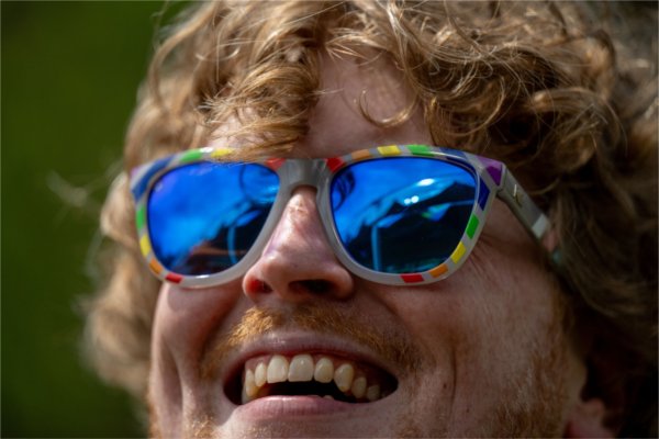Luke Madden, &#8217;08 and &#8217;21, records coordinator in the registrar&#8217;s office, smiles while wearing rainbow sunglasses as he celebrates the Pride by the Pond event on the Valley Campus June 3.